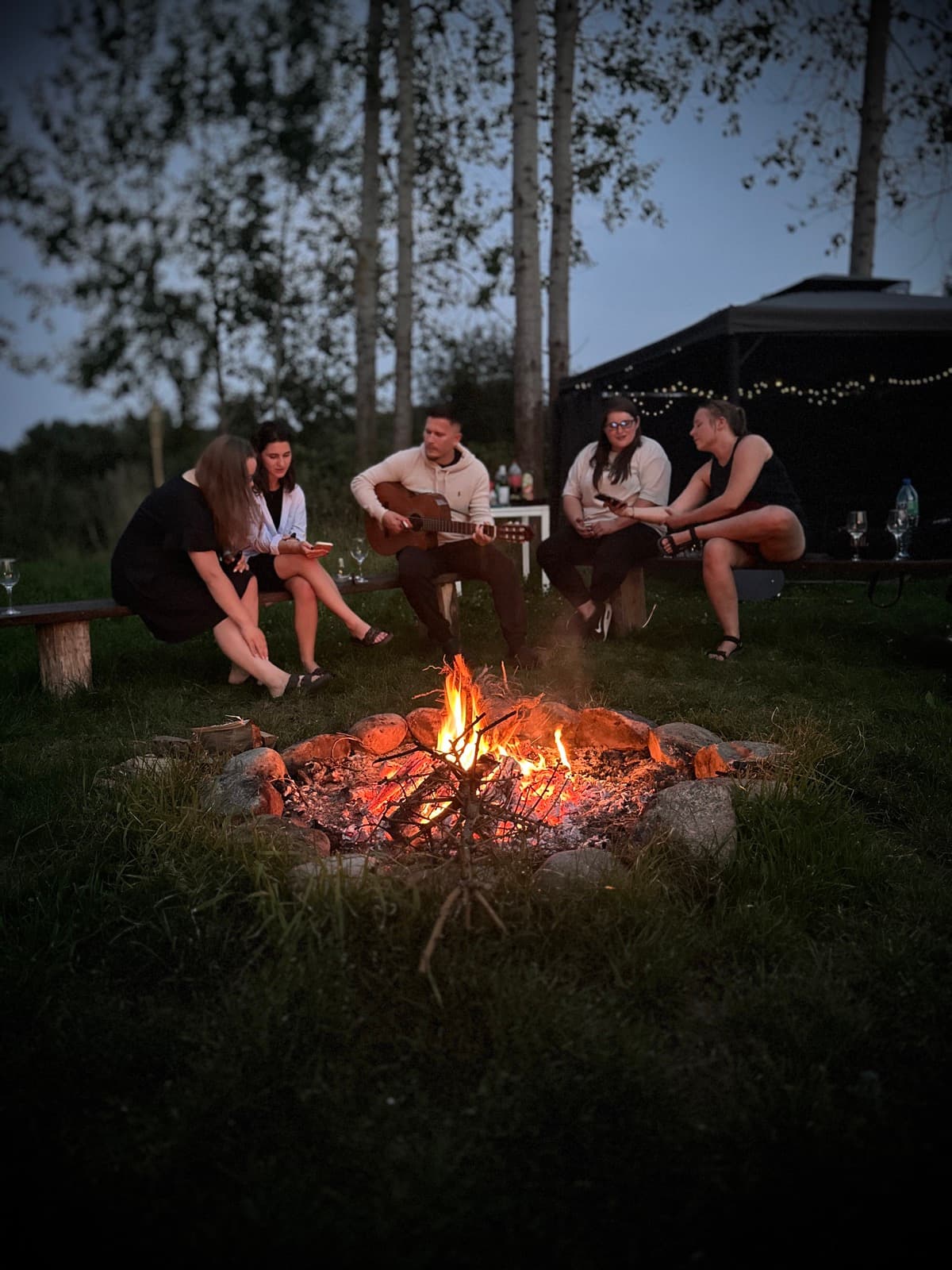 Wieczór przy ognisku z gitarą — grupa przyjaciół