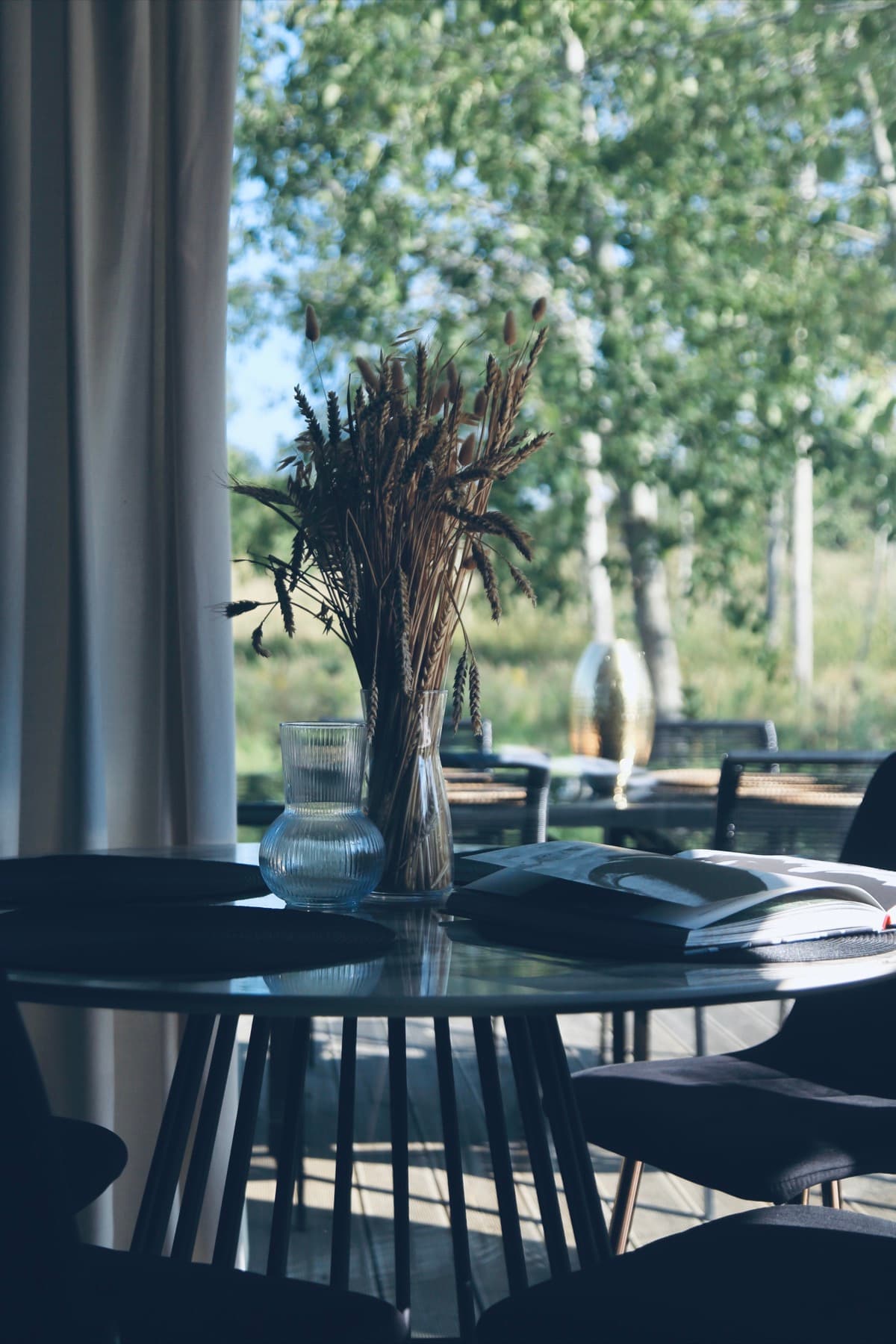 Stół jadalny z widokiem na brzozy przez duże okno