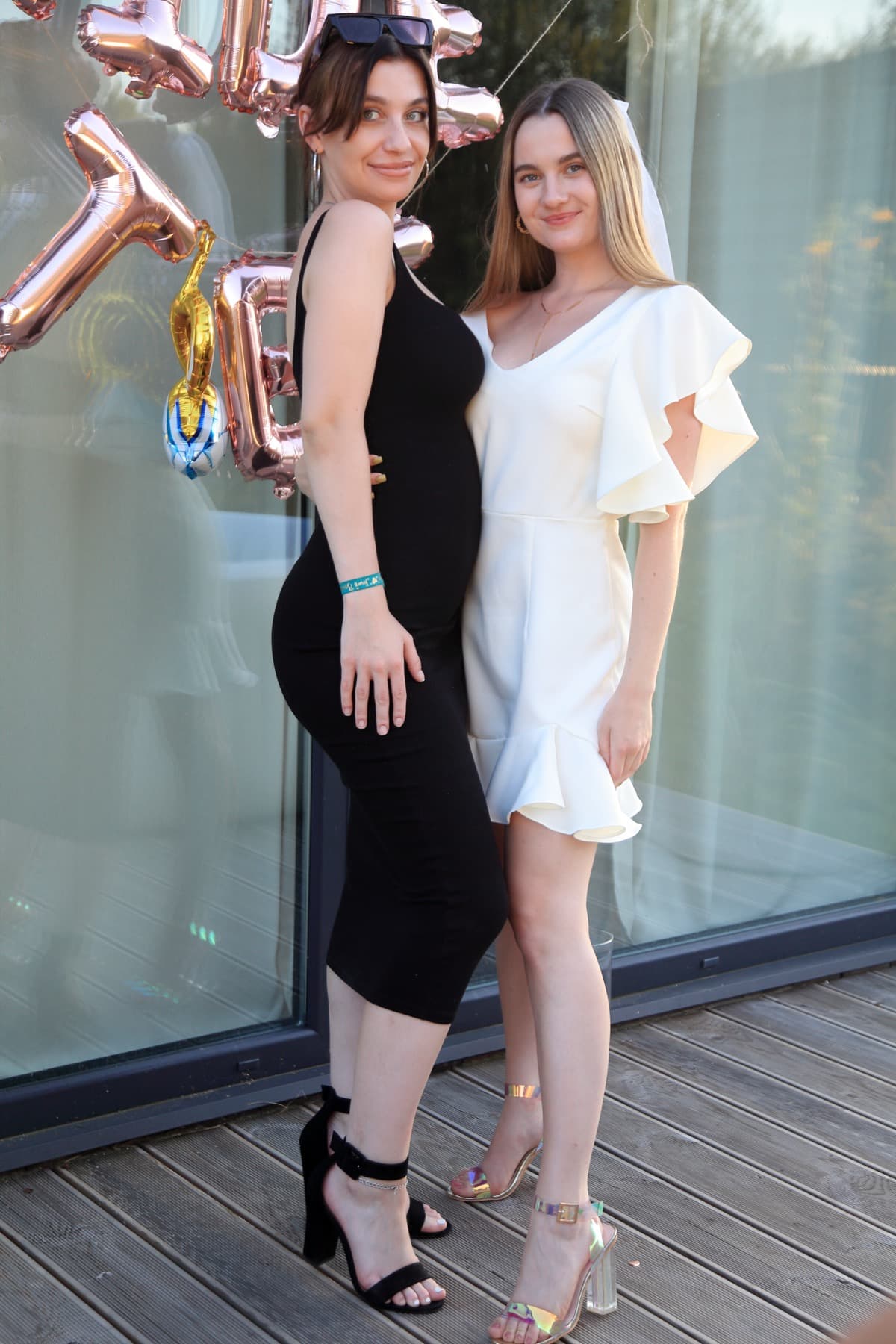 Dwie przyjaciółki pozujące z balonami na tarasie