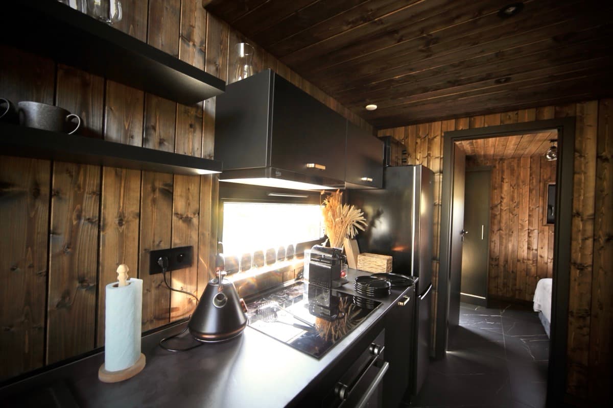 Minimalistyczna jadalnia z widokiem na las przez okna